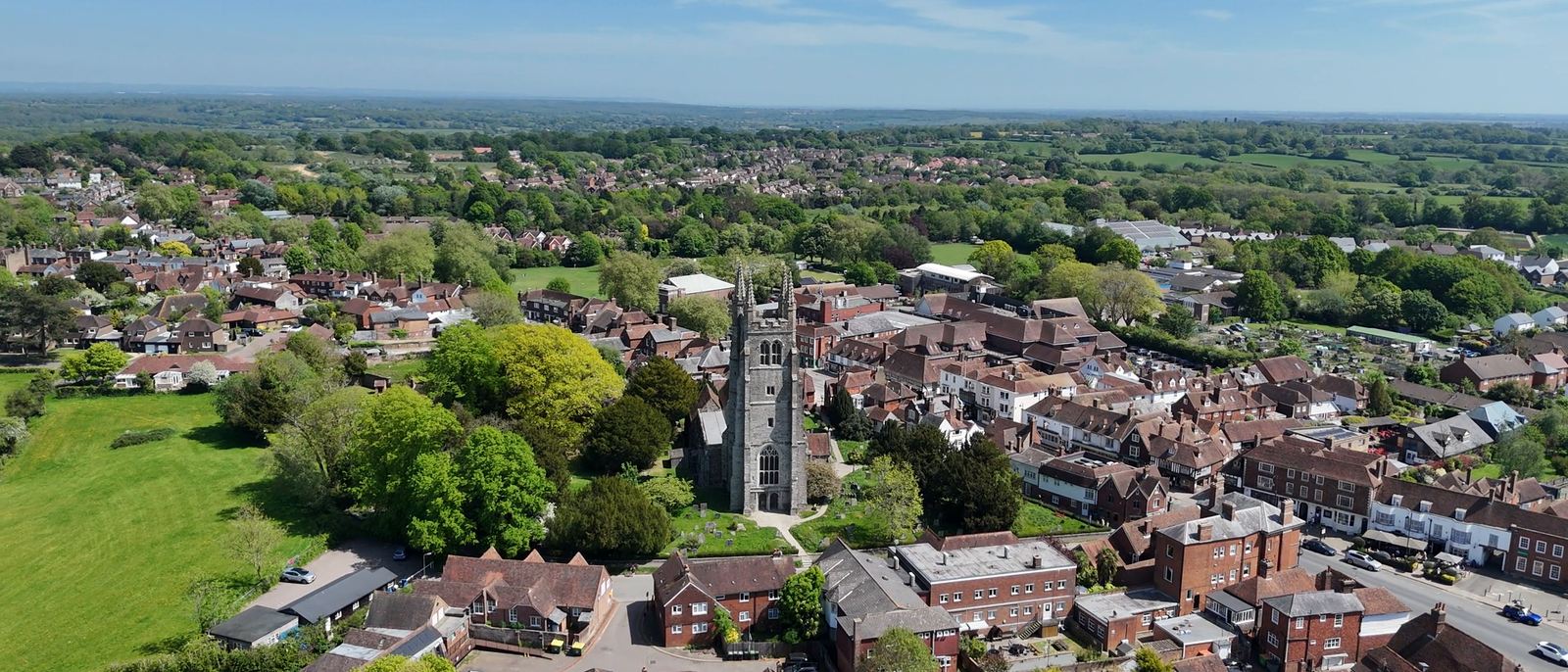 Aerial view of an English town showing a wide range of housing around a church